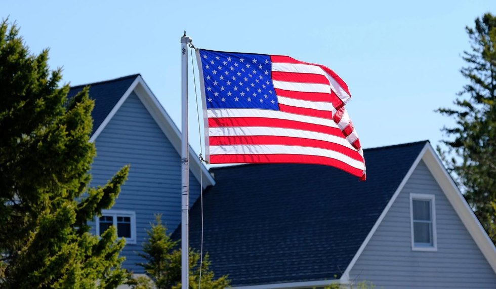 American flag in foreground with residential rooftop in background